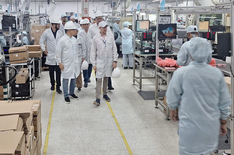 Foto mostra homens equipados com capacetes e jalecos brancos