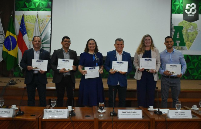 Foto mostra grupo de pessoas com certificado nas mãos