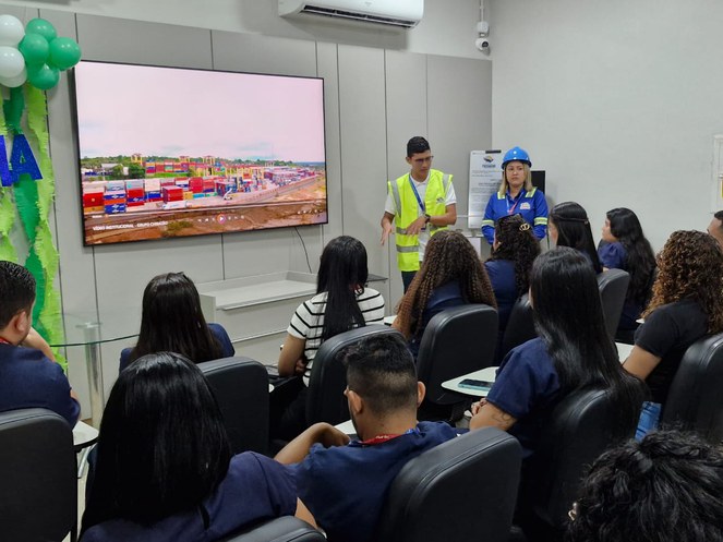 Foto mostra homem em pé e de colete fazendo uma explanação a grupo de pessoas
