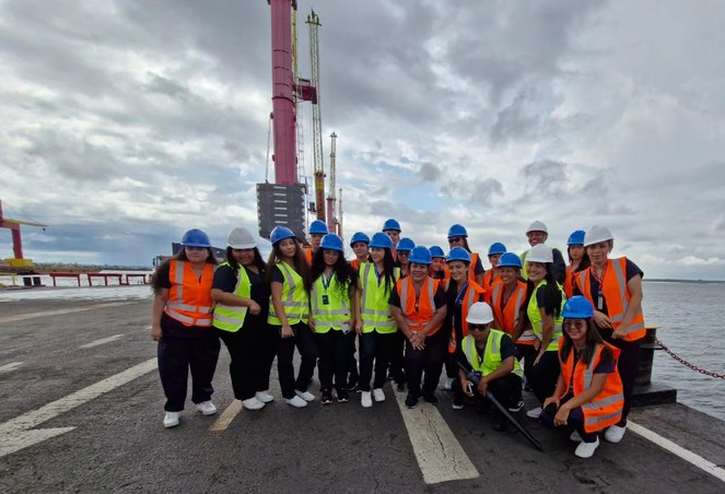Foto mostra pessoas posando para sessão de fotografia em um porto flutuante