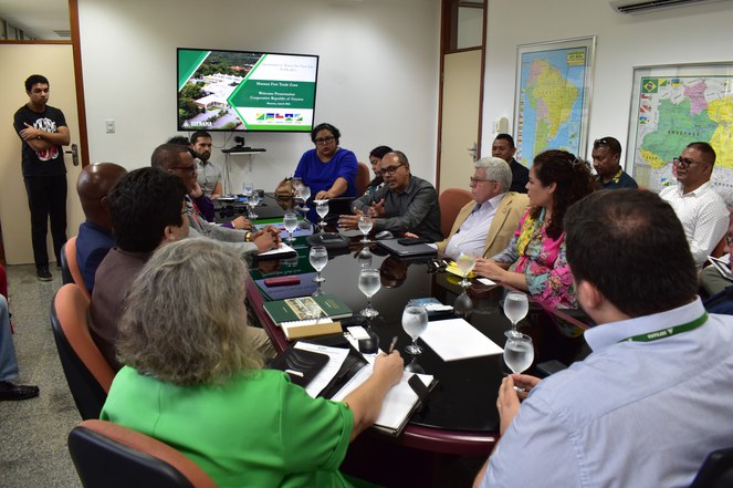 Foto mostra reunião entre um grupo de pessoas em uma sala fechada