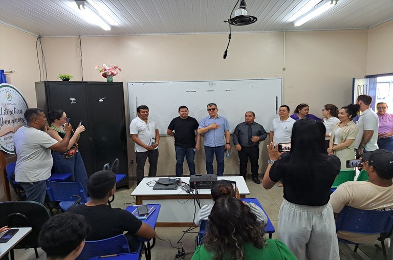 Foto com pessoas em pé reunidas em uma sala