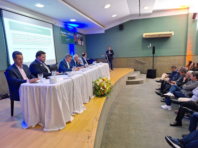 Foto mostra autoridades à mesa ouvindo explanação de técnico da Suframa em evento da Fecomércio-AM