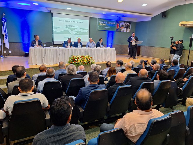 Foto mostra pessoas assistindo a um pronunciamento do superintendente-adjunto Executivo da Suframa em evento na Fecomércio-AM
