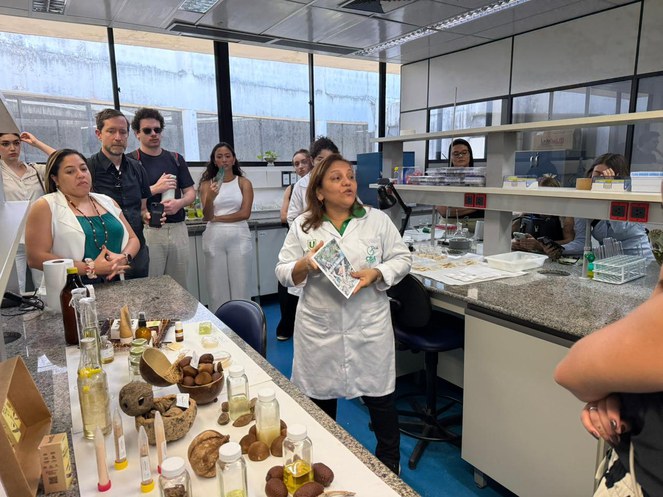 Foto mostra uma mulher fazendo explanação a um grupo de pessoas