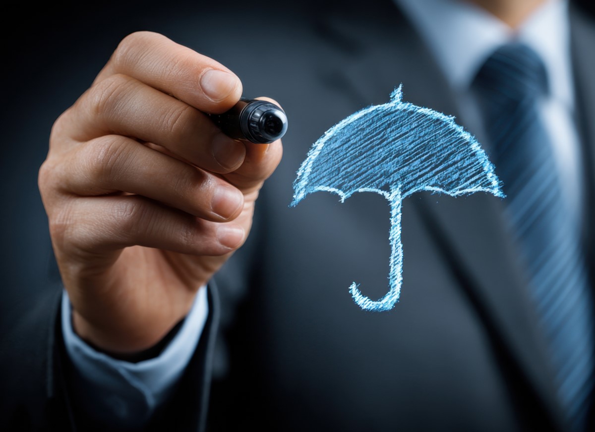 Executivo desenhando um guarda-chuva simbolizando proteção
