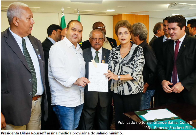 Foto da Dilma Roussef segurando o papel que corresponde a lei