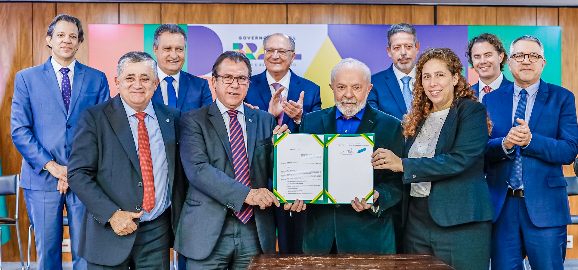 Foto do luíz marinho segurando papel com a lei 14.663