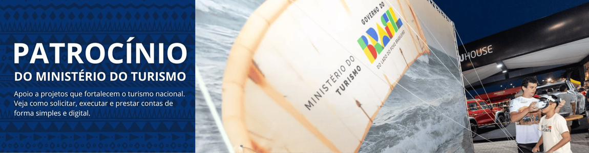 Imagem institucional dividida em duas partes. À esquerda, sobre fundo azul com grafismos geométricos, aparece o texto em destaque: “Patrocínio do Ministério do Turismo”. Abaixo, em letras menores, lê-se: “Apoio a projetos que fortalecem o turismo nacional. Veja como solicitar, executar e prestar contas de forma simples e digital.” À direita, fotografia de um evento cultural realizado à noite, com estrutura metálica de palco, banners e pórtico de entrada com logotipos institucionais e do festival. Pessoas circulam pelo espaço, indicando um evento com público presente. No alto, há um balão inflável com a marca “Brasil – União e Reconstrução” e a identificação do Ministério do Turismo, reforçando o caráter institucional e governamental do apoio ao evento.