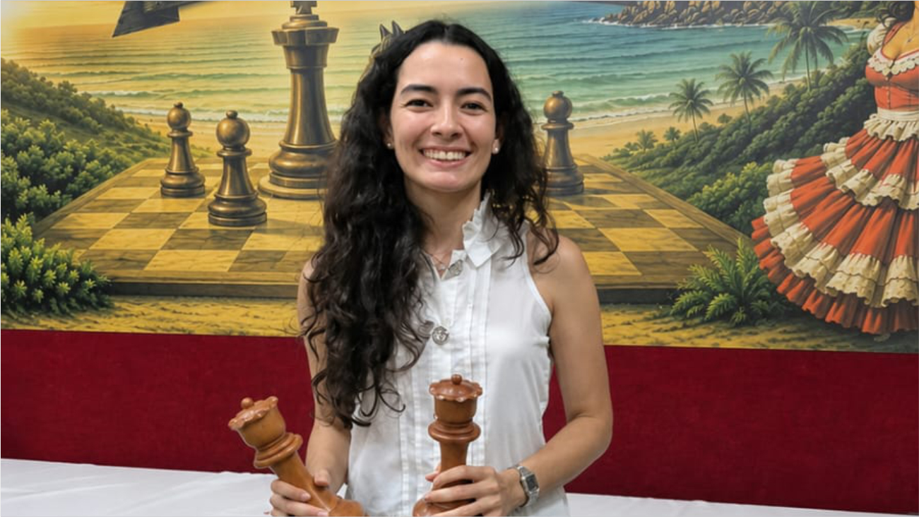 Imagem de Sara Medeiros segurando duas peças de xadrez