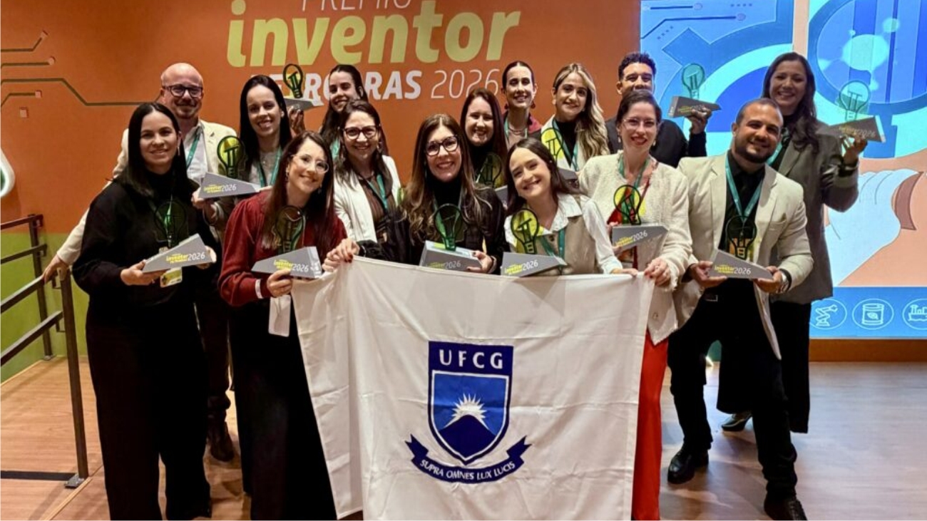 Grupo de pesquisadores segurando uma bandeira da UFCG