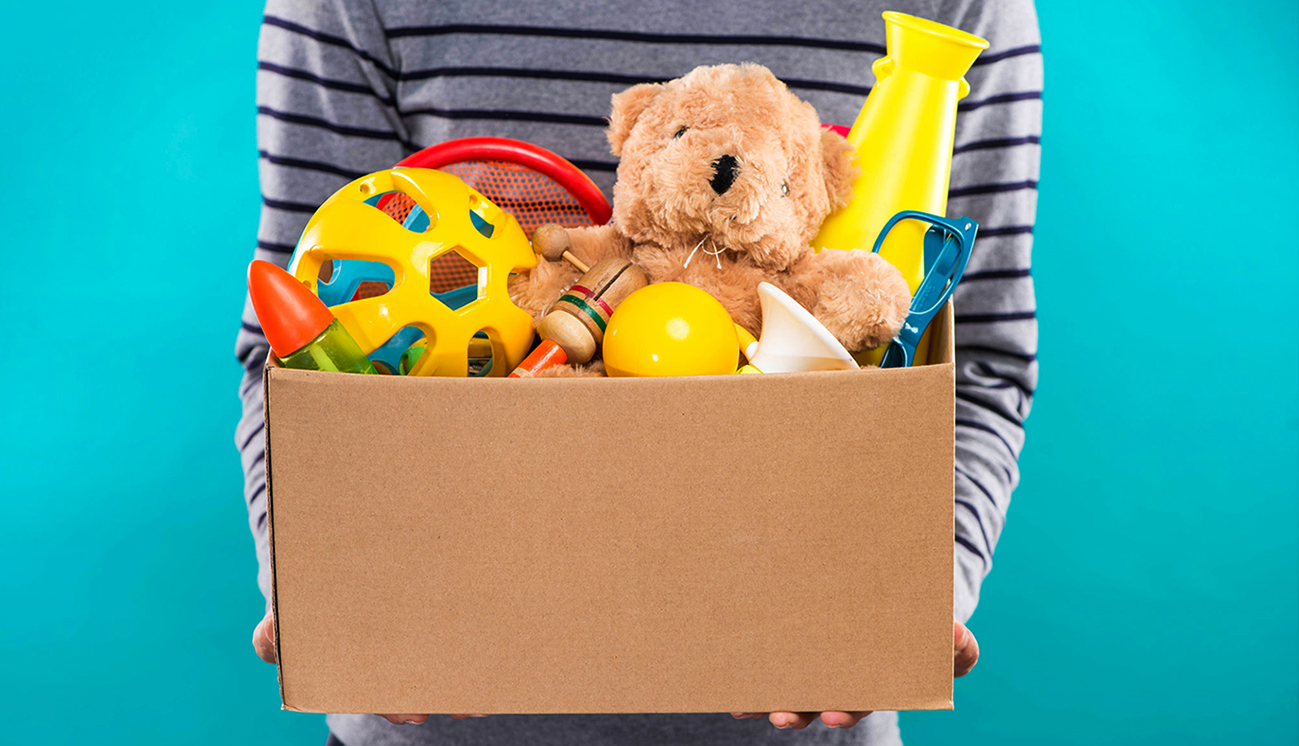 uma caixa cheia de brinquedos, num gesto de doação por uma criança