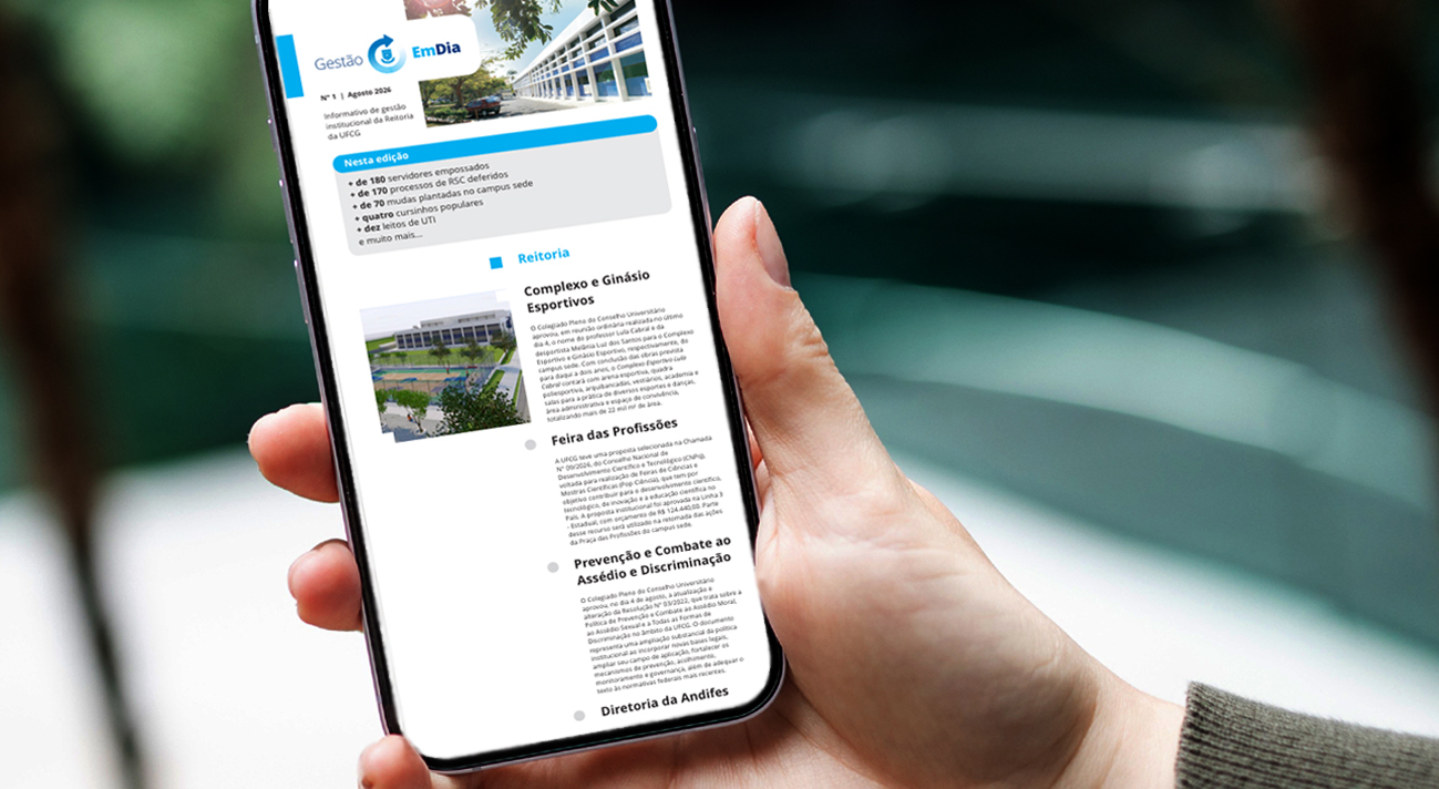 Uma mão segurando um celular ,com o informativo de gestão